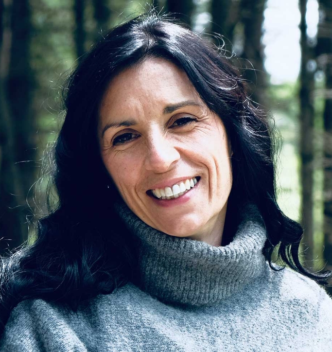 Femme souriante dans une forêt ensoleillée